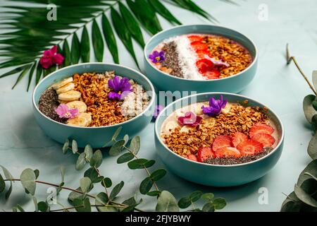 Verschiedene Smoothie-Schalen mit Obst und Müsli Stockfoto