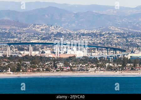 Die Coronado-Brücke von San Diego zur Coronado-Insel zeigt Werften unter der Brücke mit Bergen und Vororten in der Hintergrund und der Pazifik Stockfoto