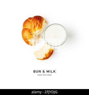 Ein Glas Milch und frisches Brötchen kreatives Layout auf weißem Hintergrund. Gesunde Ernährung und Ernährung Konzept. Gesundes Frühstück. Flach liegend, Draufsicht. Designhelmen Stockfoto