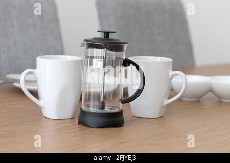 Eine Cafetiere und weiße Kaffeetassen Stockfoto