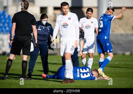 Karlsruhe, Deutschland. April 2021. Philipp Hofmann (KSC) liegt mit einer Knieverletzung auf dem Boden. Teamarzt Dr. Marcus Schweizer (KSC) (versteckt) und Physiotherapeutin Julia Bohn (KSC) eilen vorbei. GES/Football/2. Bundesliga: Karlsruher SC - Erzgebirge Aue, 26. April 2021 Fußball: 2. Liga: Karlsruher SC vs Erzgebirge Aue, Karlsruhe, 26. April 2021 zur weltweiten Nutzung Kredit: dpa/Alamy Live News Stockfoto