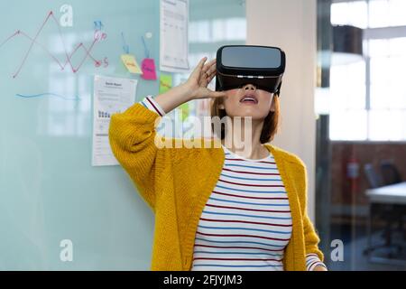 Porträt einer asiatischen Geschäftsfrau, die vor dem Whiteboard steht Virtual Reality-Headset Stockfoto
