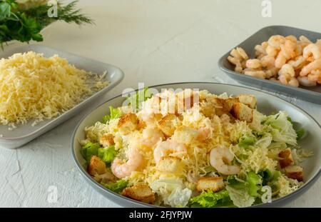 Hausgemachter Shrimp Caesar Salat mit Parmesa, Sauce und Croutons auf weißem Hintergrund. Stockfoto