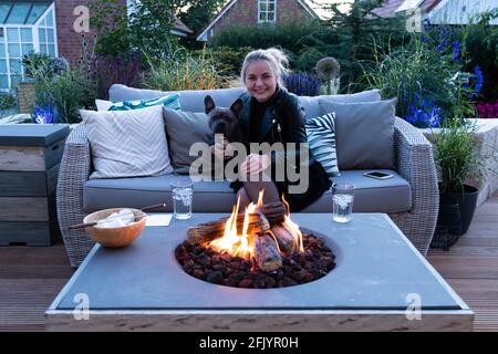 Warmer und gemütlicher Abend am Tisch der Gasfeuerstelle Stockfoto