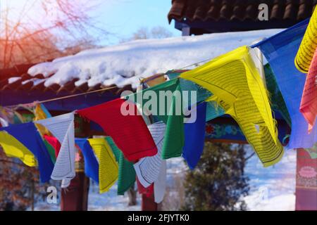 Buddhistische tibetische Gebetsfahnen flattern im Wind. Farbenfrohe tibetische Flaggen, die von Sonnenuntergang beleuchtet werden. Stockfoto