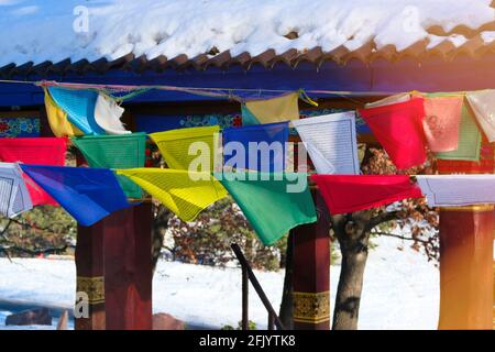 Buddhistische tibetische Gebetsfahnen flattern im Wind. Gebetsfahnen mit Farben des warmen Sonnenuntergangs. Stockfoto