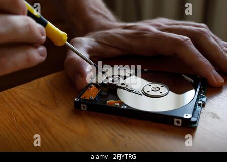 Ein Reparatur- und Renovierungskonzept für Festplatten und Festplatten. Reparaturman stellt Dateninformationen von defekter festplatte wieder her. Stockfoto