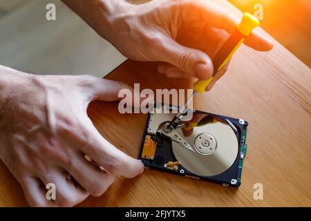 Ein Reparatur- und Renovierungskonzept für Festplatten und Festplatten. Reparaturman stellt Dateninformationen von defekter festplatte wieder her. Stockfoto