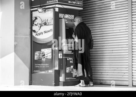 Ein buddhistischer Mönch zieht Bargeld von EINER Geldautomaten, Yangon, Myanmar. Stockfoto