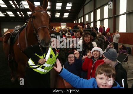 Ayrshire Equitation Center Reiten für Behinderte. Kinder aus verschiedenen Schulen um Ayrshire kamen, um Santa zu treffen, sammelten ihre Rosetten und die Möglichkeit, Pferde von Police Scotland zu treffen Kinder aus Southcraig treffen auf das Polizeipferd Cathcart und den Polizeibeamten Kirsteen Watson Stockfoto