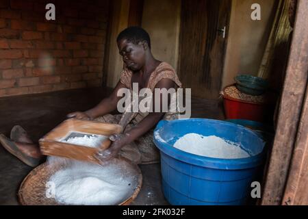 Mzuzu, Malawi. 30-05-2018. Eine schwarze Frau arbeitet in ihrem Haus und strebt Mehl, um in einem ländlichen Dorf in Malawi zum Kochen verwendet zu werden. Stockfoto