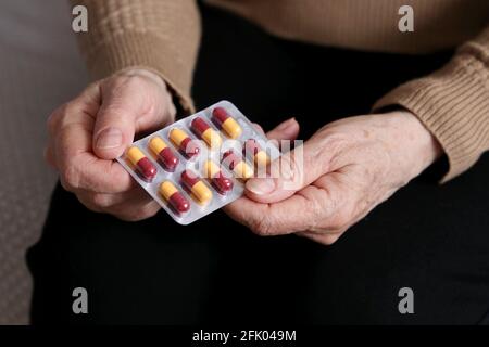 Ältere Frau mit Pillen in faltigen Händen. Medikamente in Kapseln, Einnahme von Beruhigungsmitteln, Antibiotika oder Vitaminen Stockfoto