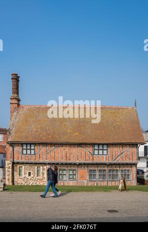Aldeburgh Suffolk, Blick auf Menschen, die an der Moot Hall aus dem 16. Jahrhundert, dem heutigen Stadtmuseum, entlang der Strandpromenade in Aldeburgh, Suffolk, England, spazieren gehen Stockfoto