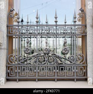 Antike schmiedeeiserne Gitter an den Fenstern eines alten europäischen Gebäudes. Die Architektur von Sankt Petersburg. Stockfoto