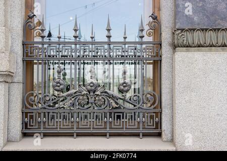 Antike schmiedeeiserne Gitter an den Fenstern eines alten europäischen Gebäudes. Die Architektur von Sankt Petersburg. Stockfoto