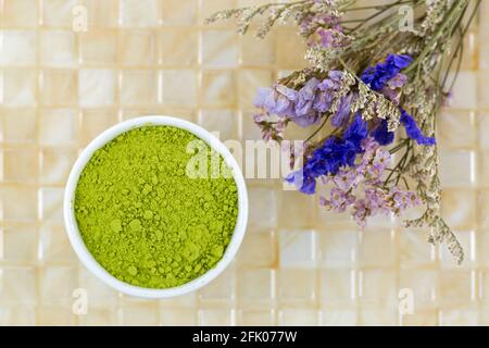 Feines japanisches Matcha-Grünteepulver auf gelbem Fliesenhintergrund, Draufsicht Stockfoto