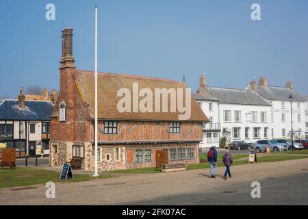 Aldeburgh Suffolk, Blick auf Menschen, die an der Moot Hall aus dem 16. Jahrhundert, dem heutigen Stadtmuseum, entlang der Strandpromenade in Aldeburgh, Suffolk, England, spazieren gehen Stockfoto