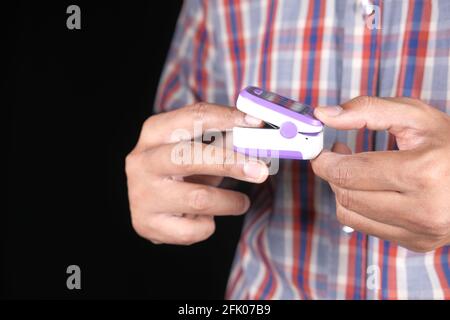 Nahaufnahme der menschlichen Hand mit einem isolierten Pulsoximeter Schwarz Stockfoto