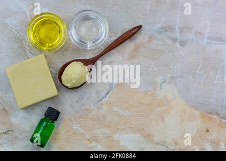 Sheabutter, kaltgepresst Bio Jojoba Golden, Kokosöl, hausgemachte Olivenölseife, reiner ätherischer Konzentrat Öl-Extrakt in grüner Flasche auf Stein Stockfoto