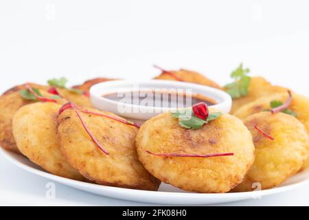 Dekorierter Teller Mit Den Beliebtesten Indischen Chaat Snacks Aloo Tikki Auch bekannt als Alu Ki Tikkia EIN gewürzter gekochter Kartoffelpüree Kartoffelschnitzel Oder Patties Serviert Mit Stockfoto