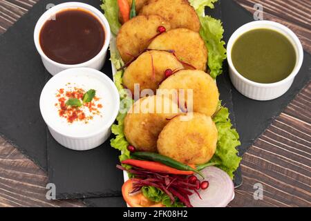 Dekorierte Platte Mit Köstlichem Aloo Tikki, Auch Bekannt Als Alu KI Tikkia EIN gewürztes Kartoffelpüree oder Patties Serviert Mit Dhaniya Pudina Gre Stockfoto