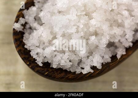 Nahaufnahme Blume des Salzes, gesammelt aus der dünnen Schicht auf der Meerwasseroberfläche, im Holzlöffel. Auf Französisch Fleur de sel genannt. Stockfoto