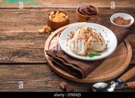 Kaltes Dessert, Eis mit Keksen und Schokolade auf Holzboden. Stockfoto