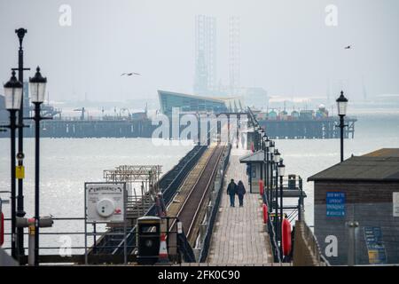 Southend am Sea Pier, Essex, Großbritannien, im Frühling, mit Blick auf die Eisenbahnlinie, mit Menschen, die gegen die Kälte eingehüllt sind. Stockfoto