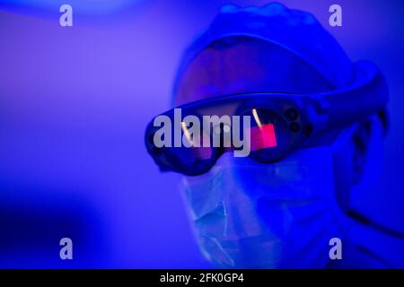 Essen, Deutschland. April 2021. Ein Mann trägt im HNO-Operationssaal des Universitätsklinikums eine Brille, die eine dreidimensionale Wiedergabe chirurgischer Bilder ermöglicht. Der Bau des neuen Operationssälen für den Eye- und ENT-Betrieb kostete fast 70 Millionen Euro. Dies sind laut Universitätsklinikum derzeit die modernsten Operationssäle in Deutschland und Europa. Quelle: Jonas Güttler/dpa/Alamy Live News Stockfoto