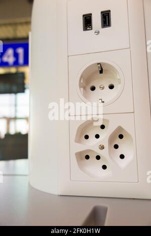 Array von elektrischen Ladebuchsen ( inkl. USB-Buchse ) zum Laden der elektrischen Batterien in mobilen Geräten von Passagieren / Passagier. Flughafen Genf Cointrin, Schweiz. Stockfoto