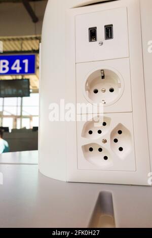 Array von elektrischen Ladebuchsen ( inkl. USB-Buchse ) zum Laden der elektrischen Batterien in mobilen Geräten von Passagieren / Passagier. Flughafen Genf Cointrin, Schweiz. Stockfoto