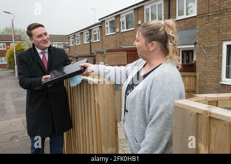 Mansfield Woodhouse, Nottinghamshire, England, Großbritannien. April 2021. Wes Streeting Labour Party M.P. für ilford North und Shadow Minister for Education (Schulen) (links) sprachen mit einer lokalen Mansfield Woodhouse Residenz Vicki Chapell (rechts) über die Spende eines Laptops und wie es ihrer Familie helfen soll, online auf ihre Schule zuzugreifen, um während der Sperre zu lernen. Quelle: Alan Beastall/Alamy Live News Stockfoto