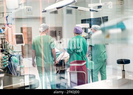 Essen, Deutschland. April 2021. Ein Team von Ärzten und chirurgischen Assistenten steht während einer Operation im HNO-Operationssaal der Universitätsklinik um einen Patienten herum. Der Neubau des Operationsflügels für den Augen- und HNO-Betrieb kostete fast 70 Millionen Euro. Dies sind laut Universitätsklinikum derzeit die modernsten Operationssäle in Deutschland und Europa. Quelle: Jonas Güttler/dpa/Alamy Live News Stockfoto