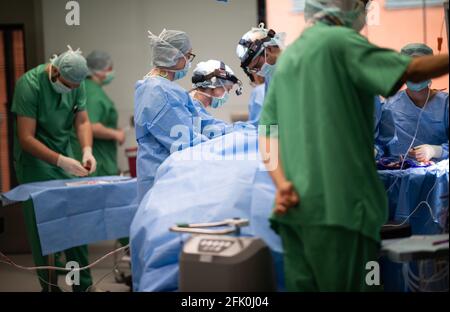 Essen, Deutschland. April 2021. Ein Team von Ärzten und chirurgischen Assistenten steht während einer Operation im HNO-Operationssaal der Universitätsklinik um einen Patienten herum. Der Neubau des Operationsflügels für den Augen- und HNO-Betrieb kostete fast 70 Millionen Euro. Dies sind laut Universitätsklinikum derzeit die modernsten Operationssäle in Deutschland und Europa. Quelle: Jonas Güttler/dpa/Alamy Live News Stockfoto