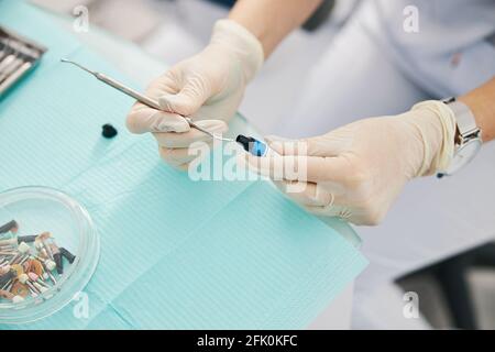 Person Tauchen zahnmedizinisches Instrument in Dental Composite-Füllflasche Stockfoto