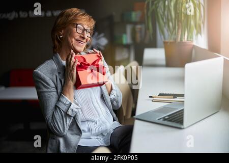 Erstaunliche weibliche Person, die auf ihren Laptop schaut Stockfoto