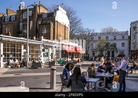 Menschen saßen vor Cafés und Restaurants auf der Exhibition Road, nachdem die Lockerung der Zwangsabsperrung gelockert wurde, South Kensington, London, Großbritannien, Europa Stockfoto