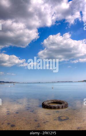 In Poole's sitzt ein alter Traktorreifen im Schlamm Hafen bei Ebbe Stockfoto