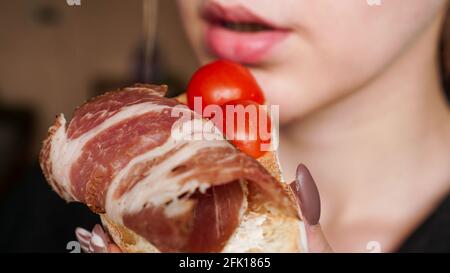 Nahaufnahme. Frau beißt frische Bruschetta mit Kirschtomate Stockfoto