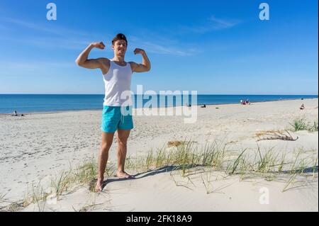 Region Königsberg, Ostsee, Russland, 10. Mai 2020. Sportliches Design. Junger Mann am Strand. Junger Mann, der sich auf dem Meer ausruht. Stockfoto
