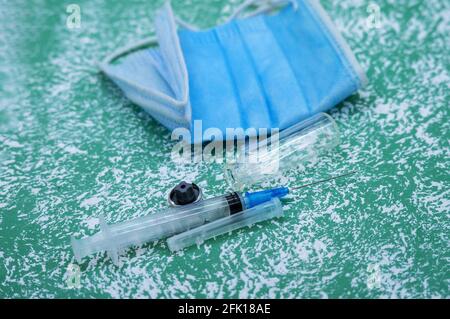 Medizinische Instrumente auf blauem Hintergrund. Banner mit medizinischen Gegenständen. Medizinische Maske und Impfstoff. Ampulle aus Medizin und Spritze. Stockfoto