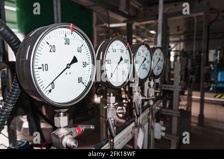 Das Manometer ist ein Nahaufdruck-Messgerät in einer Reihe. Messung des Flüssigkeits- und Gasdrucks in Industrieanlagen Stockfoto