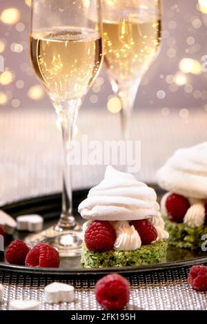 St. Valentine festliche Tischkulisse mit zwei Champagner-Gläser und Beerenmeringue Desserts auf Tablett stehen auf silbernen funkelnden Tisch, weiße Herzen, b Stockfoto