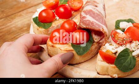 Italienische Vorspeise. Bruschetta auf einem Holzbrett auf einem rustikalen Holzhintergrund Stockfoto