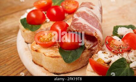 Italienische Vorspeise. Bruschetta auf einem Holzbrett auf einem rustikalen Holzhintergrund Stockfoto