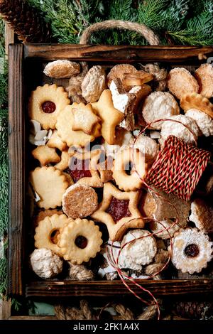 Weihnachten hausgemachte Shortbread Kekse Kekse Sammlung verschiedene Formen, darunter traditionelle Linz Kekse mit roter Marmelade in Holztablett über Thuja b Stockfoto