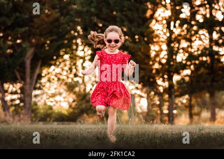 Mädchen läuft im Sommer in Frankreich durch Grasfeld Stockfoto