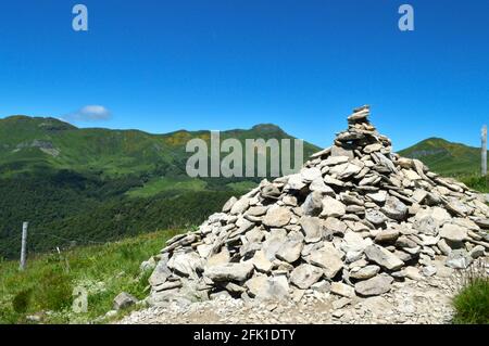 Ein Cairn, der von Wanderern auf einem Berg gemacht wurde Vor einer Berglandschaft Stockfoto