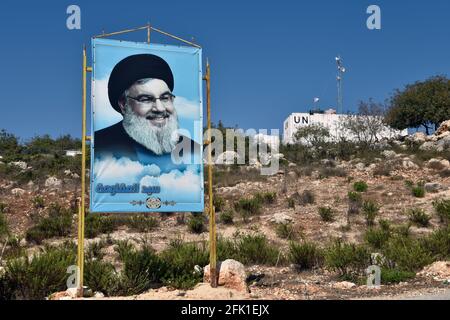 Plakat mit Hisbollah-Generalsekretär Sayyed Hassan Nasrallah, hinter dem UNIFIL-Posten, Marwhien, Südlibanon. Stockfoto