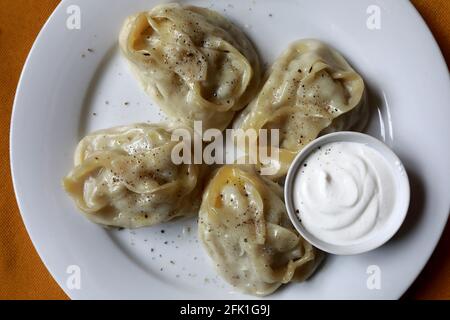 Manty mit Pfeffer auf dem Teller im Restaurant Stockfoto